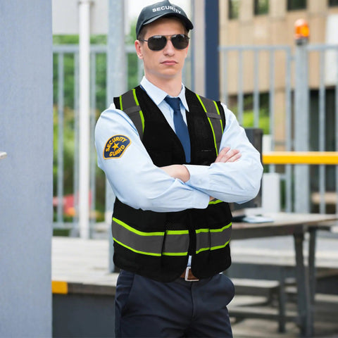 Top Shelf Seven Pocket Mesh Safety Vest In Matte Black For Active Crews Featuring Fly Airflow Polyester worn by a security guard.