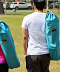 Two people carrying Low Profile Beach Chair 2 Pack For Adults Folding And Portable With Cup Holder And Carry Bag Perfect For Beach Boat River Sand Concerts Camping And Kids For Everyday Outdoor Fun And No Fuss Setup on their shoulders.