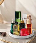 Lazy Susan Turntable Organizer 10 Inch 360 Degree Rotating Tray in white holding beauty and skincare essentials on a marble countertop