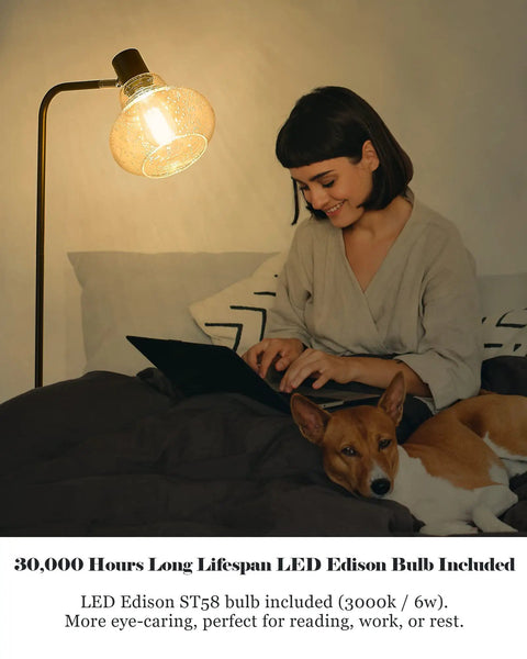 Farmhouse Bubble Glass Floor Lamp With Adjustable Tall Pole in bedroom setting, woman using laptop, oil rubbed bronze finish