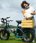 Fat Tire Electric Bike For Adults With 28 MPH Top Speed, 48V Power, And 80 Mile Range next to person with basket in park.