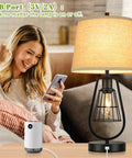 Woman smiling with Industrial Touch Table Lamp with USB Port, 3-Way Dimming, cream fabric shade, black metal base beside her