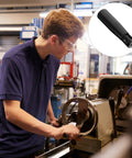 Heavy Duty Black Bakelite Folding Swivel Crank Handle For Machines in use, attached to a lathe for better control.