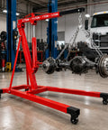5000 Lbs Folding Engine Hoist Cherry Picker Crane Hydraulic Pump Heavy Duty Alloy Steel Frame holding an axle in a garage.