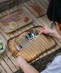 Trail Ready Stainless Steel Camping Utensil Kit With Spoon Fork Chopsticks being laid out on table during picnic