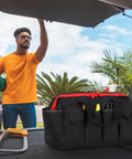 Man packing a Pro Grade 16 Inch Tool Bag Organizer With 17 Pockets And Adjustable Shoulder Strap for men and DIYers in car trunk