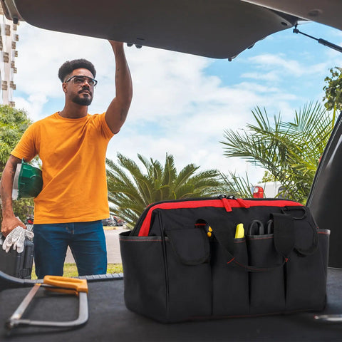 Man packing a Pro Grade 16 Inch Tool Bag Organizer With 17 Pockets And Adjustable Shoulder Strap for men and DIYers in car trunk