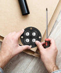 Hands placing Swivel Caster Wheels 360 Degree Rotation Self Adhesive 12pcs Mini on a surface with a screwdriver.