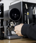 Heavy Duty 58mm Automatic Coffee Tamper With Adjustable Portafilter Bracket And Snappy Digital Touch Control delivering precise pressure on espresso machine.