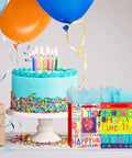 Two Pack 12.6 Inch Large Happy Birthday Gift Bags With Tissue Paper for Birthday Party Supplies next to a birthday cake with balloons.