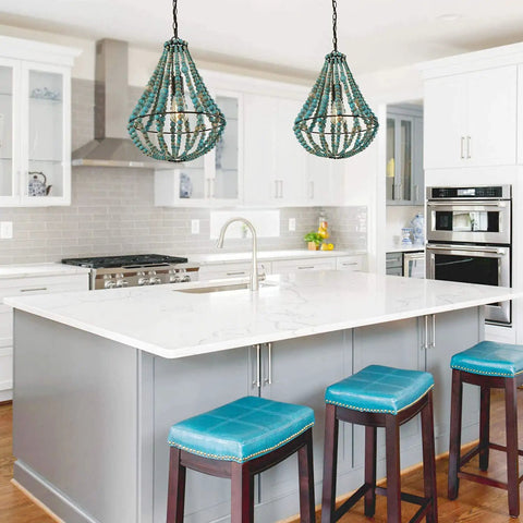 Two Wood Beaded Chandelier Light Fixtures in rustic grey blue hang above a kitchen island, showcasing a boho farmhouse vibe.