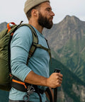 Man hiking with backpack carrying 3in1 Lighter With Multitool Keychain And Bottle Opener on waist, mountains in background