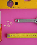 40Pc Copper Flat Washer Set For Oil Drain Plugs And Hydraulic Lines on pink background with tools and tape measure