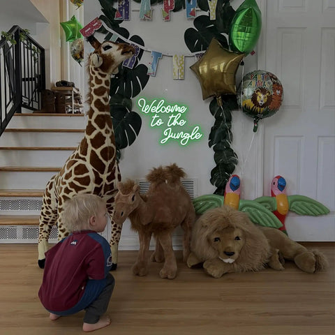 Welcome To The Jungle Neon Sign Green LED Light For Wall Decor USB Powered Jungle Theme Decor For Garden Home Entryway Front Porch Totally Lit Neon Letter Sign, surrounded by plush jungle animals
