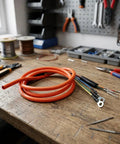Upgrade Your Ride With Heavy Duty E Bike Motor Extension Cable Featuring Premium Pure Copper Core And High Conductivity For 1000W Systems Designed To Handle Massive Loads Without Voltage Drop While Staying Super Durable And Weatherproof In Any Climate. orange e-bike motor extension cable with copper core and ring terminals on workbench