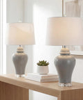 27 Inch Gray Ceramic Urn Table Lamps Set Of 2 With White Linen Shade For Living Room And Bedroom, LED Bulbs Included, Dope Farmhouse Style Bedside Lights, ETL Listed For Safety on a wooden table.