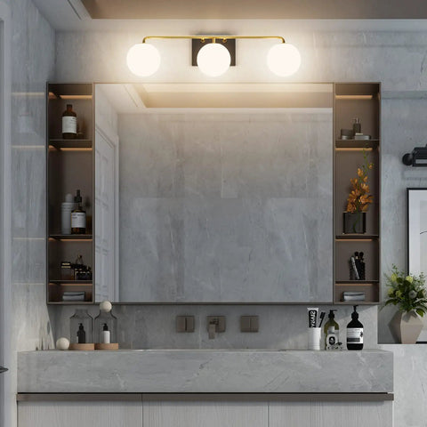 Three Light Mid Century Vintage Bathroom Vanity Light Fixtures Over Mirror Black and Gold Industrial Vanity Lights With Milk White Glass Globe For Farmhouse Bath Lighting mounted above mirror in modern decor bathroom.