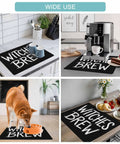Spooktacular Black Witches Brew Coffee Station Mat Featuring Quick Dry Absorbent PU Material Designed For Kitchen Counter Espresso Machine Setup 28 By 18 Inch Halloween Spill Proof Drip Catch Pad with mugs and espresso maker.