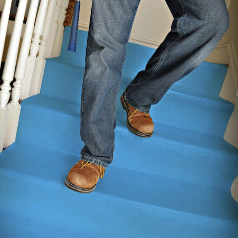 Man walking on 24 Inch By 100 Foot Surface Protector For Hardwood Vinyl Tile Marble And Stairs Waterproof Reusable Repositionable Pad