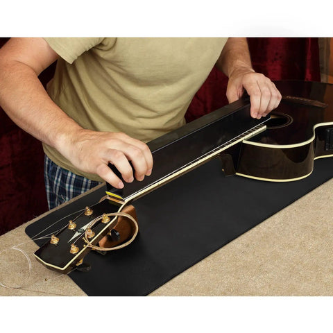 Person using All In One Guitar Repair Kit With Neck Rest Cradle And Pro Grade Gig Ready Work Mat for instrument maintenance.