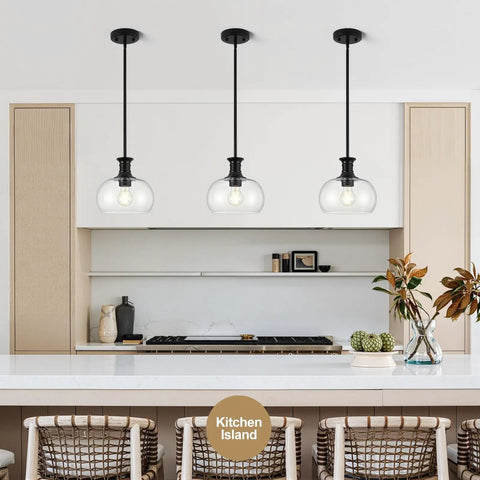 puncoll 2 PK 9 Inch Modern Black Clear Glass Pendant Light above a kitchen island with three pendant lights.