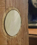 Close-up of a predrilled wooden door hole plug for two one eighth inch holes DIY ready hand made wafer style wood plug for door repair.