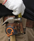 Worker using Leather Tool Holster With Hammer Loop, Tape Measure Holder, And Pencil Pouch For Belt on jobsite, tools visible.