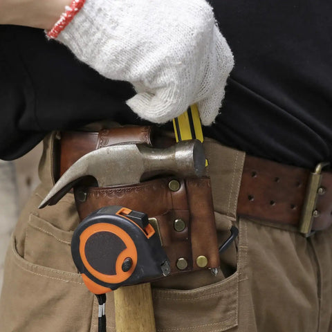 Worker using Leather Tool Holster With Hammer Loop, Tape Measure Holder, And Pencil Pouch For Belt on jobsite, tools visible.