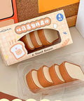 Box of toast-shaped erasers displayed on a desk, styled like food items, four pieces included.