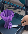 Hand using Beefy Dual Edge 3D Printer Scraper Kit With Curved And Straight Blades on 3D print model
