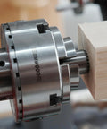 Top Tier Crown Drive Center With Spring Loaded Point fits four jaw chuck securely gripping raw timber for wood turning.