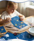 Child using Dope Sun Print Cyanotype Kit With 30 Sheets Of Paper And Acrylic Panel for nature crafts on a table