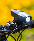 Lars Rover Power 850 USB Rechargeable Bicycle Headlight with Battery Meter mounted on bike handlebars, sunny background
