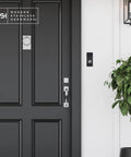 Sick Modern Stainless Doorbell Black R7 Series With Anodized Aluminum Button next to a black door in a stylish entryway.