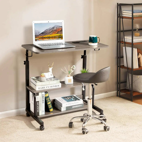 Unwind And Handle Daily Grind At This Grey Oak Rolling Standing Desk With Height Adjustable Top Smooth Gliding Wheels Grab And Go Mobility Side Hooks And Roomy Storage Shelves For Your Home Office Setup with laptop on the surface.