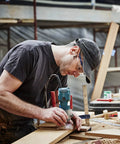 Woodworker using router in workshop with Pro Grade 35 Piece Router Bit Kit One Quarter Inch Shank Carbide Bits for woodworking