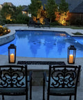 Large Outdoor Solar Powered Lantern With Open Frame No Glass Black Metal 19 Inch Tall Dusk To Dawn Timer Flickering LED Candle Lantern For Porch Patio Garden Rustic Farmhouse Vibe by a poolside at dusk