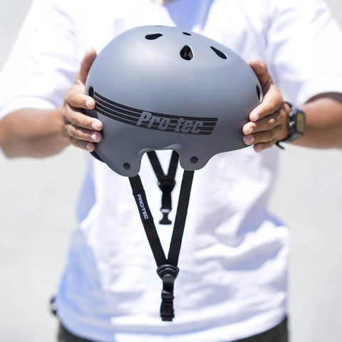 Person holding Old School Low Pro Certified Helmet With Deep Fit And SlimTech Core for Skateboarding, BMX, Cycling, and Roller Skating.