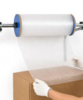 No Sweat Wall Mount Bubble Wrap Roll Dispenser With Flexible Snap Connector And Secure Side Locks For Pro Warehouse Shipping Or Heavy Weekend Moving Day Packing Jobs, dispensing bubble wrap onto a box.