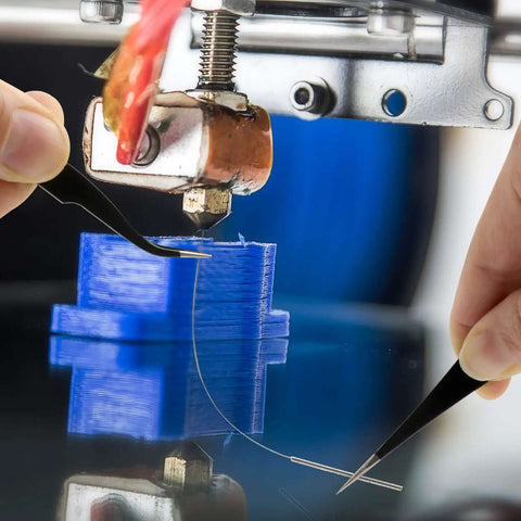 Close-up of a hand using tweezers to insert a cleaning needle into a 3D printer nozzle, part of 3D Printer Nozzle Cleaning Kit 13 Piece Set.
