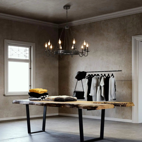 Black Industrial Wagon Wheel Chandelier Pendant Light in rustic room above a wooden table, displaying 10 lights in candle style.