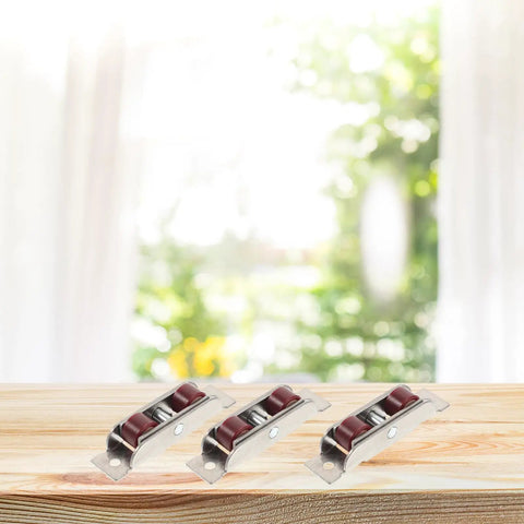 Heavy Double Wheel Sash Rollers For Sliding Windows And Patio Doors on a wooden surface with blurred background.
