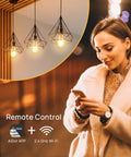 Smart Edison Bulbs WiFi LED E26 Dimmable ST64 Vintage Filament Light Bulb 45W Equivalent 2200K Soft White 350lm in pendant lights over a woman using a smartphone.