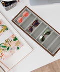 Slick Wooden Sunglasses Display Tray With Soft Gray Velvet Lining Seven Grid Eyewear Organizing Rack with sunglasses on a desk.