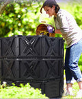 Woman using 540L Outdoor Tumbler Compost Bin For Garden And Yard, Extra Large BPA Free All Season Composting Box in backyard.