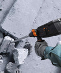 Heavy Duty 1 Inch Rotary Hammer Drill With SDS Plus 6.5 Amp Motor drilling concrete with visible debris on the ground
