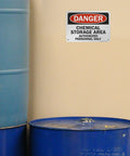 Heavy Duty Aluminum Hazard Warning Plate 7 X 10 Inches Built Like A Tank For Chemical Storage Areas And Authorized Personnel Only Rust Free Fade Resistant Print mounted next to blue barrels.
