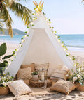 XXL Teepee Tent For Adults And Kids With Vine LED Lights Waterproof Cotton Canvas on a beach with cushions and plants