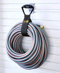 Heavy-Duty 28 Inch Storage Straps Set 2-Pack No-Fuss Hook And Loop Cord Carrier holding coiled hose in garage