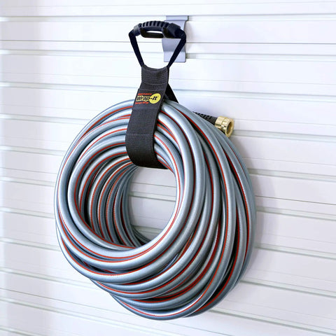 Heavy-Duty 28 Inch Storage Straps Set 2-Pack No-Fuss Hook And Loop Cord Carrier holding coiled hose in garage